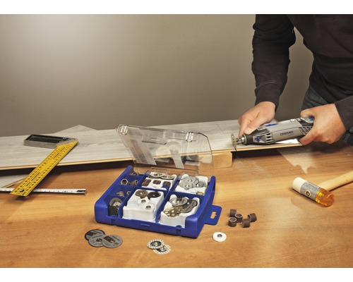 Dremel multiverktyg i bruk med tillbehörssats på en arbetsbänk i trä