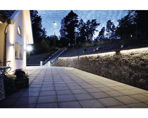 Uteplats med gatsten, stenmur och utomhusbelysning