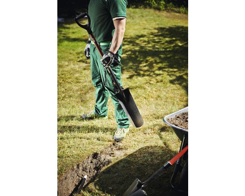 Man med spade, dike och skottkärra i trädgården