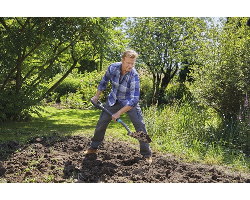 Man gräver i trädgården med en spade.