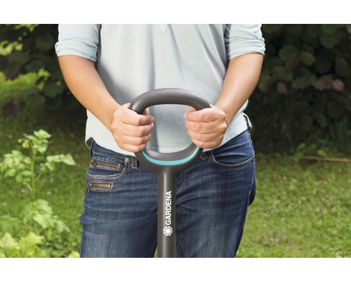 En person håller i en spade av märket Gardena.