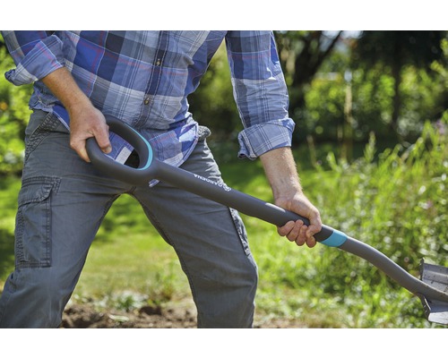 Man gräver med en spade i trädgården