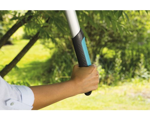 Hand håller trädgårdssax med teleskopskaft