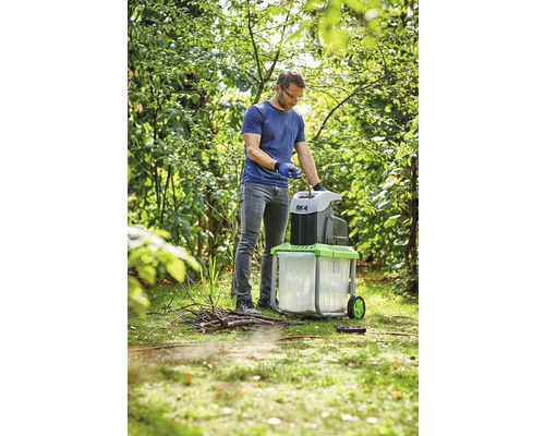 En man använder en trädgårdshackare i trädgården.