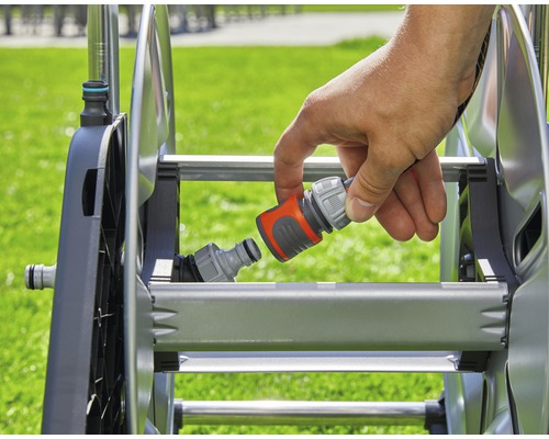 En hand ansluter en slangkoppling till en slangvinda