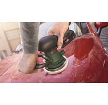 Person polerar en röd bil med en batteridriven polermaskin från Bosch