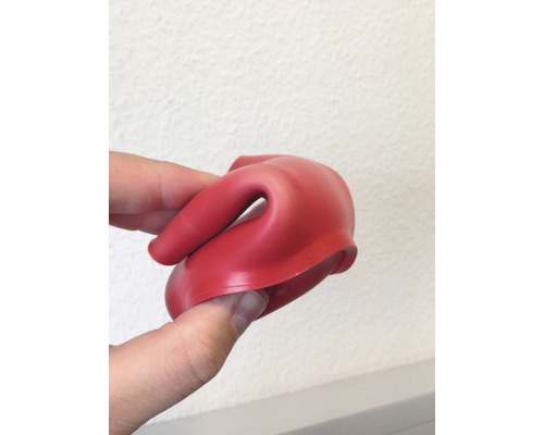 Röd gummitätning hålls av en hand.