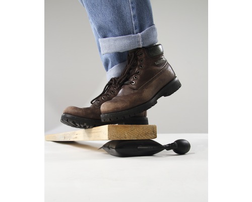 Person med stövlar balanserar på luftkudde mellan träbitar