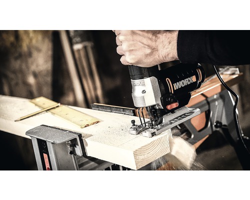 En sticksåg av märket Worx skär ett arbetsstycke.