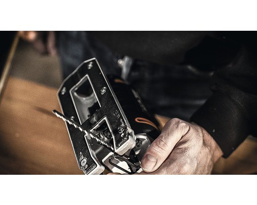 Närbild av en sticksåg med sågblad i en hand