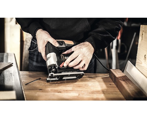 En sticksåg som används på en arbetsbänk.