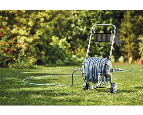 Trädgårdsslangvagn med slang i trädgården