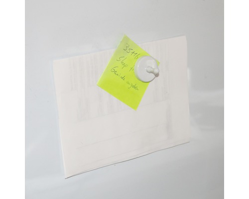 Papper med anteckning fäst med en magnet