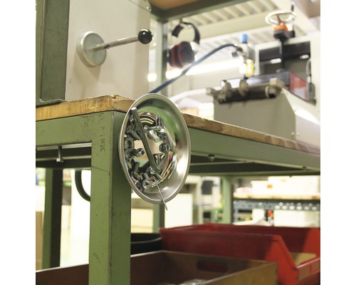 Magnetisk skål med skruvar och muttrar på ett arbetsbänk