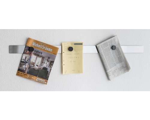 Magnetremsa på väggen med tidning, lapp och tidning fästa