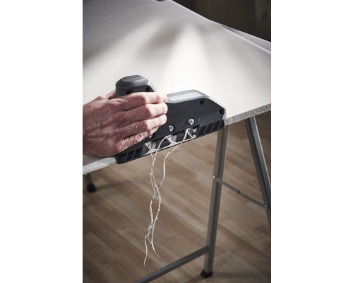 En person använder en kantputs på en gipsskiva för att skapa en ren kant.