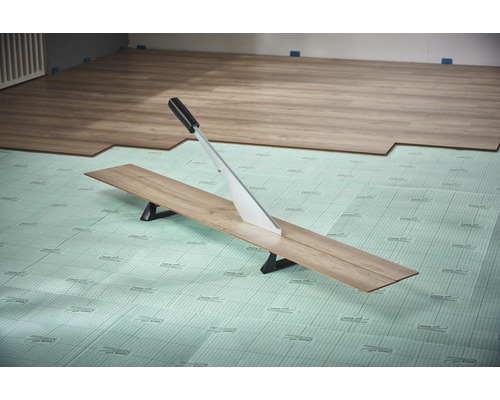 Laminatskärare skär laminatskiva på isolerande underlag