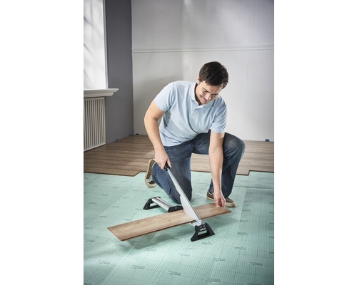 Man skär laminat med en laminatskärare