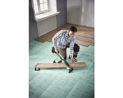 Man lägger laminat med laminatskärare på stegljudsisolering