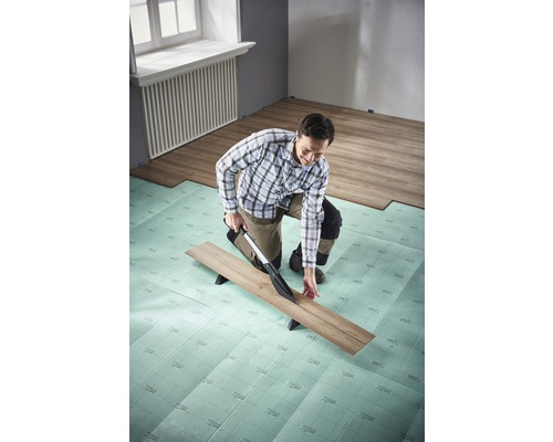 Man skär laminat med en laminatskärare på isolerande underlag i rummet