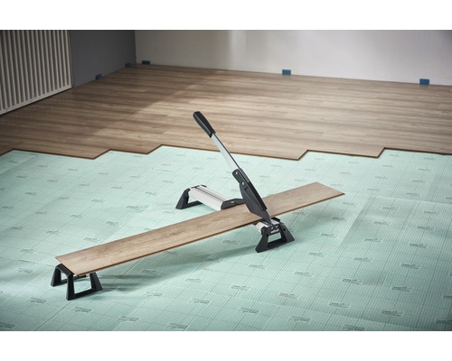 Laminatskärare som skär laminat på en isoleringsmatta