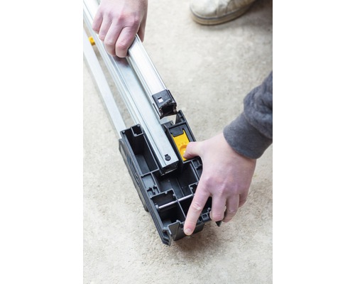 En person monterar en aluminiumram i ett fäste.