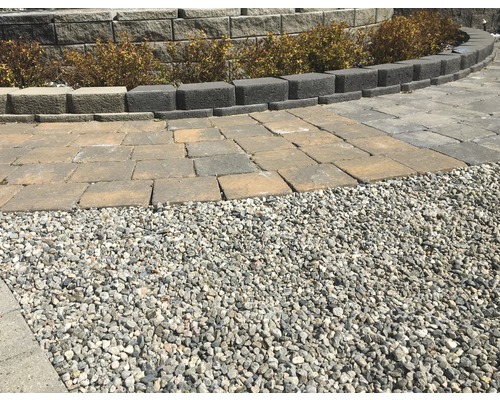 Trädgårdslandskap med dekorativt grus, gatstenar och murstenar
