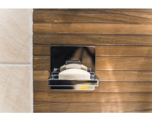 Tvålkopp i metall med tvål på en trävägg