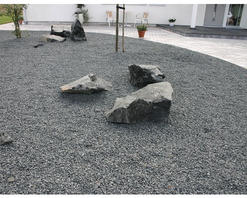 Utomhusområde med dekorativt grus och stora stenar.