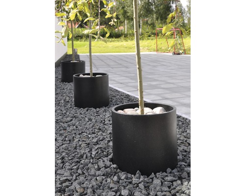 Tre planteringskärl i trädgården med grusbädd