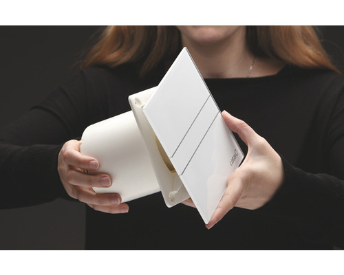 Person håller en frånluftsfläkt av märket Cata.