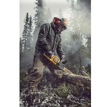 En person sågar en trädstam med en DeWalt batteridriven motorsåg. Personen bär skyddskläder och arbetar utomhus.