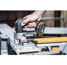 Batteridriven sticksåg i bruk för att skära ett arbetsstycke. Worx logotyp.