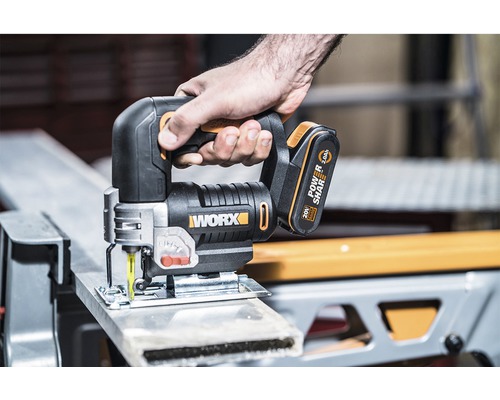 Batteridriven sticksåg i bruk för att skära ett arbetsstycke. Worx logotyp.