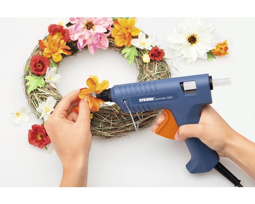 Dekorativ krans är dekorerad med limpistol och konstgjorda blommor.