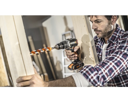 Man borrar ett hål i en träskiva med en sladdlös borrmaskin.