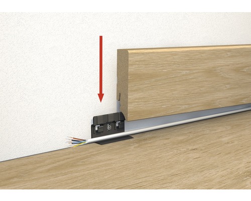 Illustration av montering av en trägolvslist med kabelkanal och en röd pil som visar monteringsriktningen.