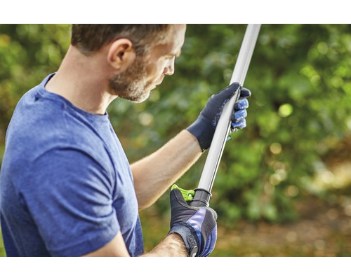 En person med handskar håller ett trädgårdsredskap.