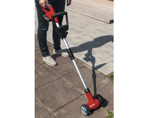 Person använder sladdlös fogrensare på gatstenar