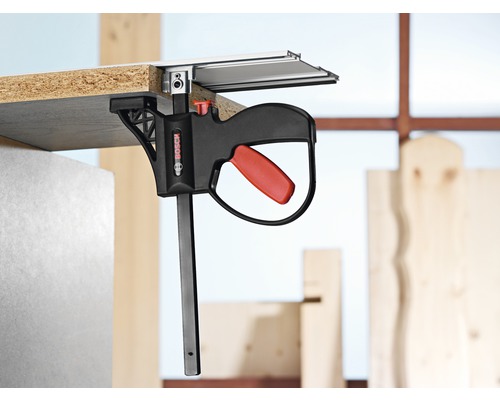 Bosch logotyp. Arbetsstycke fixerat till styrskenan med Bosch enhandsspännare.