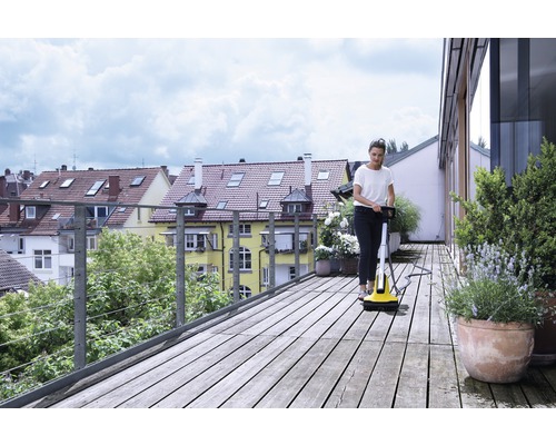 Kvinna rengör träterrass med terrasstvätt