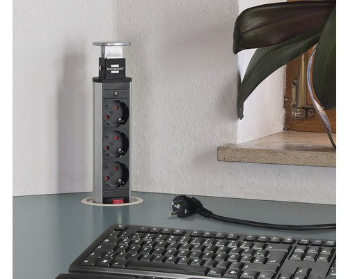 Infälld grenuttag med tre uttag på ett skrivbord.