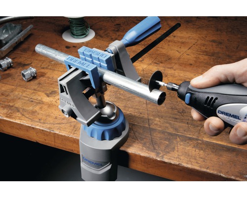 Dremel logotyp. Arbetsbänk med Dremel multiskruvstycke och Dremel multiverktyg som kapar ett rör.