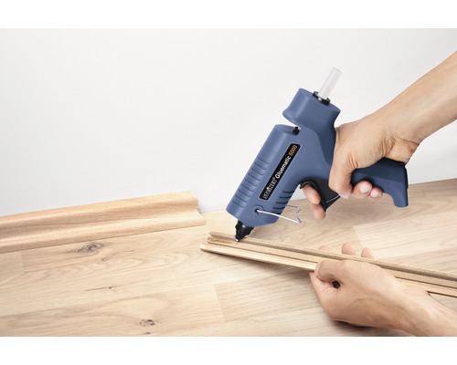 Person limmar dekorlister med en limpistol.