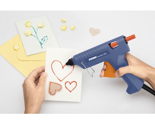 Person använder limpistol för att göra kort