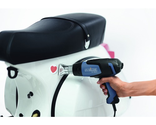 Varmluftspistol vid applicering av ett klistermärke på en skoter.