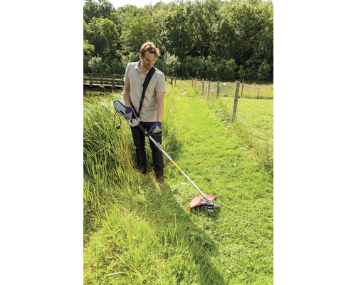 Man som arbetar med en trimmer i trädgården