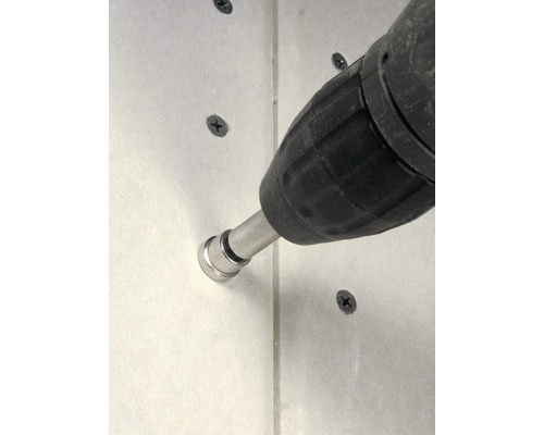 Sladdlös skruvdragare fäster skruv i en vägg