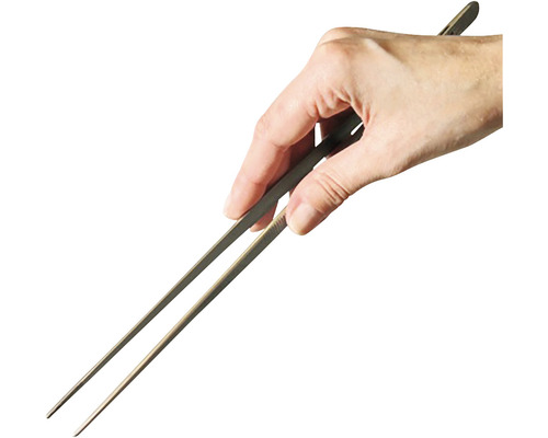 En hand håller en grilltång.