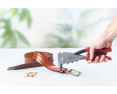 En popnittång som används på ett läderbälte med popnitar